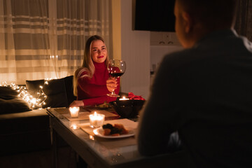 romantic dinner for two, date at home couple in love, man with woman drinking wine in glasses at...