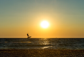 Kite boarder performing a jump at sunset