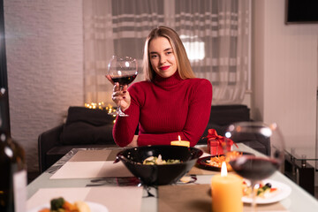 A woman with a glass of red wine, romantic dinner at home, one woman drinks alcohol, online date, romance of loneliness and love, webcam communication
