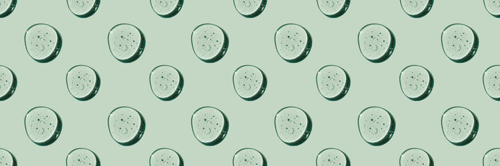 A pattern of cosmetic drops on a green natural background.