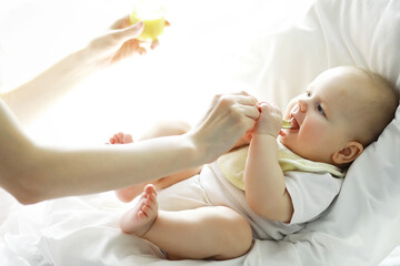 Maternity concept. A young mother feeds her little baby. First lure and breastfeeding. Family in...