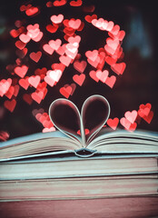 Paper book in the shape of a heart on the background of bokeh hearts. valentine's day concept.love...