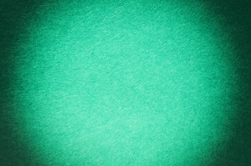 Background made of blue-green felt with a dark rectangular vignette 