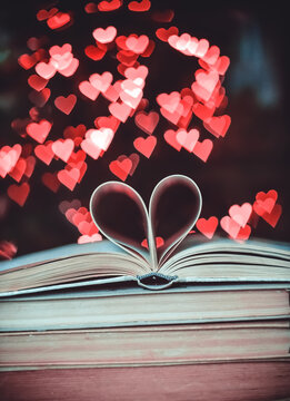 Paper book in the shape of a heart on the background of bokeh hearts. valentine's day concept.love symbol 