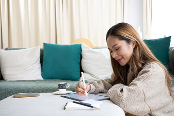 Attractive young woman working online with digital tablet at home.