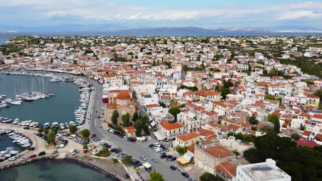Aerial drone view and view of yachts in the main marine at Aegina Island, with Ekklisia Isodia Theotokou Church in Aegina town and moored old fshing boats, Aegina Island, Greece