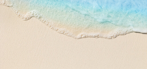 Tropical beach background with sea waves, white sand and foam - summer holiday panoramic top view...