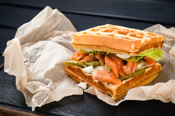 Belgian waffle with salmon on wood table. Keto Breakfast variation.
