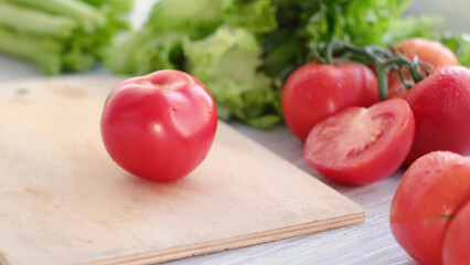 fresh juicy tomatoes close up, vegetables and and lettuce on background