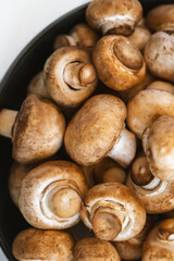 Fresh  mushrooms champignon in  bowl on white background.  Copy space.
