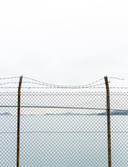 fence with wire in front of the sea