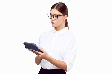 Young woman accountant with a calculator in her hands wearing white shirt glasses on a white isolated background. Business woman counting income