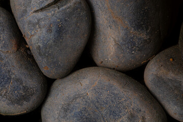 Fototapeta na wymiar Black round cobble stone texture for wallpaper and background. Abstract background. Texture background. Macro photography. Close up.