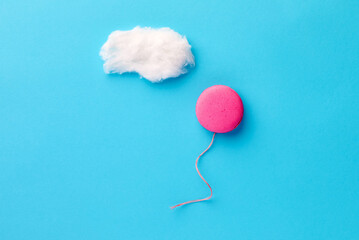 Macaroon in the form of a balloon flying in the air towards the cloud