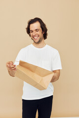 Cheerful man in a white T-shirt with paper bag Lifestyle unaltered