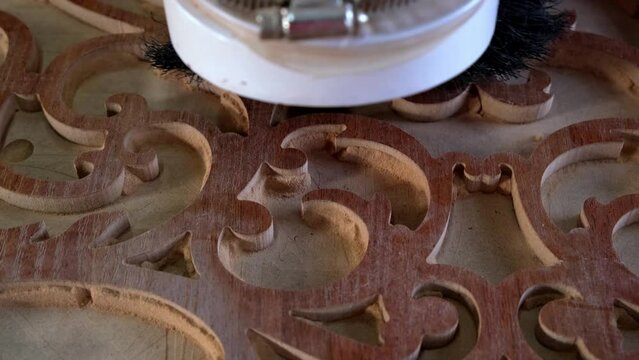 Woodworking CNC router machine cuts a pattern on a piece of wood.Close up,slow motion.