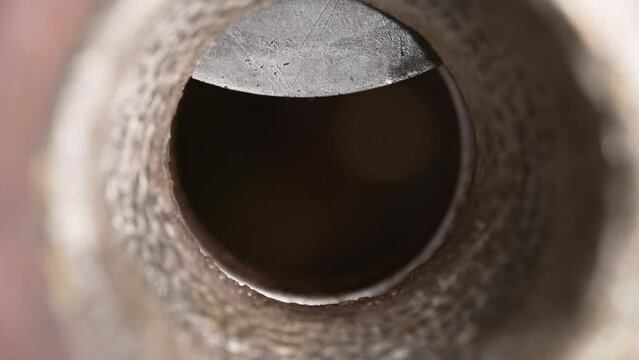 closing a metal wedge valve through which the liquid must flow. inside view. close up