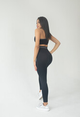 Fototapeta premium Attractive black african american woman in stylish fitness outfit top and pants on white isolated background.