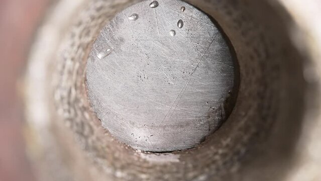 opens a metal wedge valve through which the liquid must flow. inside view. close up