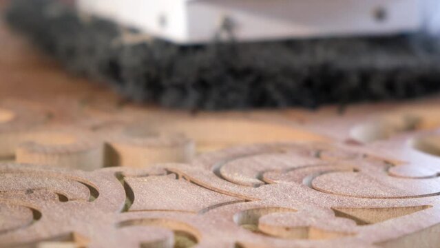 Woodworking CNC router machine cuts a pattern on a piece of wood.Slow motion.