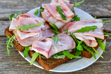 Home made healty Ketogenic diet sandwich fromWholegrain low carb bread, smoked bacon and arugula.
