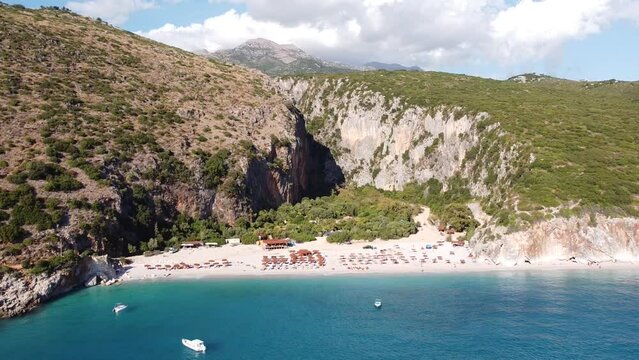 Aerial Drone View of Gjipe Beach and Canyon, Dhermi, Albania - Hidden Paraside with boats, tourists, sunbeds and blue sea