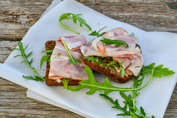 Home made healty Ketogenic diet sandwich fromWholegrain low carb bread, smoked bacon and arugula.