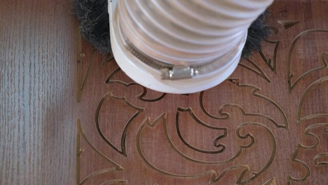 Woodworking CNC router machine cuts a pattern on a piece of wood.Close up,slow motion.
