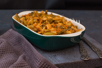 Vegetable stew with green beans and cauliflower in a green ceramic bowl.