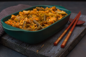 Vegetable stew with green beans and cauliflower in a green ceramic bowl.