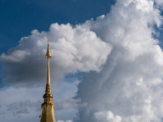 Top of The Golden Pagoda behind The Clouds and Blue Sky