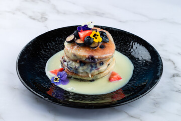 stack of pancakes with condensed milk and fresh berries