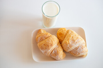 Delicious breakfast with fresh croissants, orange juice and a glass of milk.