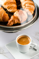 Breakfast with croissants, green leaves and black coffee composition