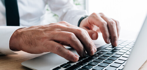 Technical writer typing laptop keyboard, closeup of hands