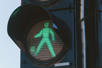 Soccer concept, pedestrian traffic light man kicking a ball