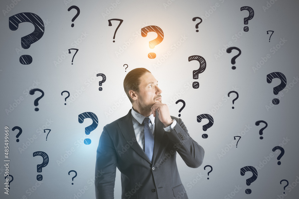 Aufkleber Portrait of attractive thoughtful young european business man on concrete wall background with question marks sketch. Solution and doubt concept.