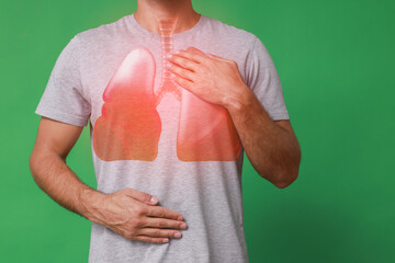 Man holding hands near chest with illustration of lungs on green background, closeup