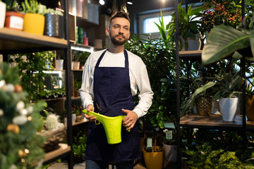 slappy garden center worker holding potted plants in the background