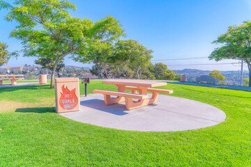 Park with picnic table and coal bin on a concrete ground at San Diego, California