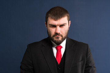Angry mafioso. A man in a suit looks into the camera with a frown. Mimicry. Evil glance. A...