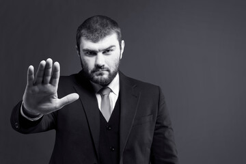 Stop. Stop hand sign. The man in the suit put his palm forward. Stop signal. Hand gesture