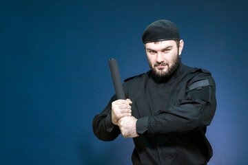 A male security guard in a black uniform and a cap took a protective stance. Bodyguard. Private...