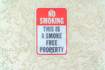 Close-up of a No smoking sign on a textured beige wall at Carlsbad, San Diego, California