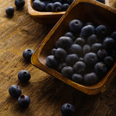 Close-up. Fresh blueberries in bowls on a wooden background. Rich harvest, vitamins, antioxidants. Cooking, ingredient for different dishes. The medicine. There are no people in the photo.