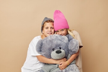 Boy and girl in multi-colored hats entertainment posing isolated background