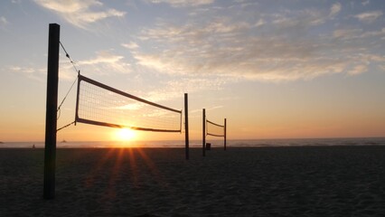 Volleyball net silhouette on beach court at sunset, California coast, USA. Sport field for volley...