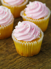 Close-up. Appetizing cupcakes decorated with pink cream. Lots of objects. Sweet food, holiday, birthday, romantic date, many calories. Restaurant, hotel, supermarket, confectionery.