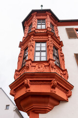 Sightseeing in Bavaria, Germany. Vibrant red architectural details of Bischöfliches Palais (Bishop's Palace) on cloudy day in summer. 