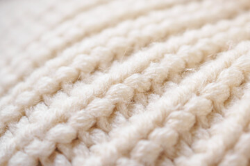closeup beige knitted woolen fabric texture background